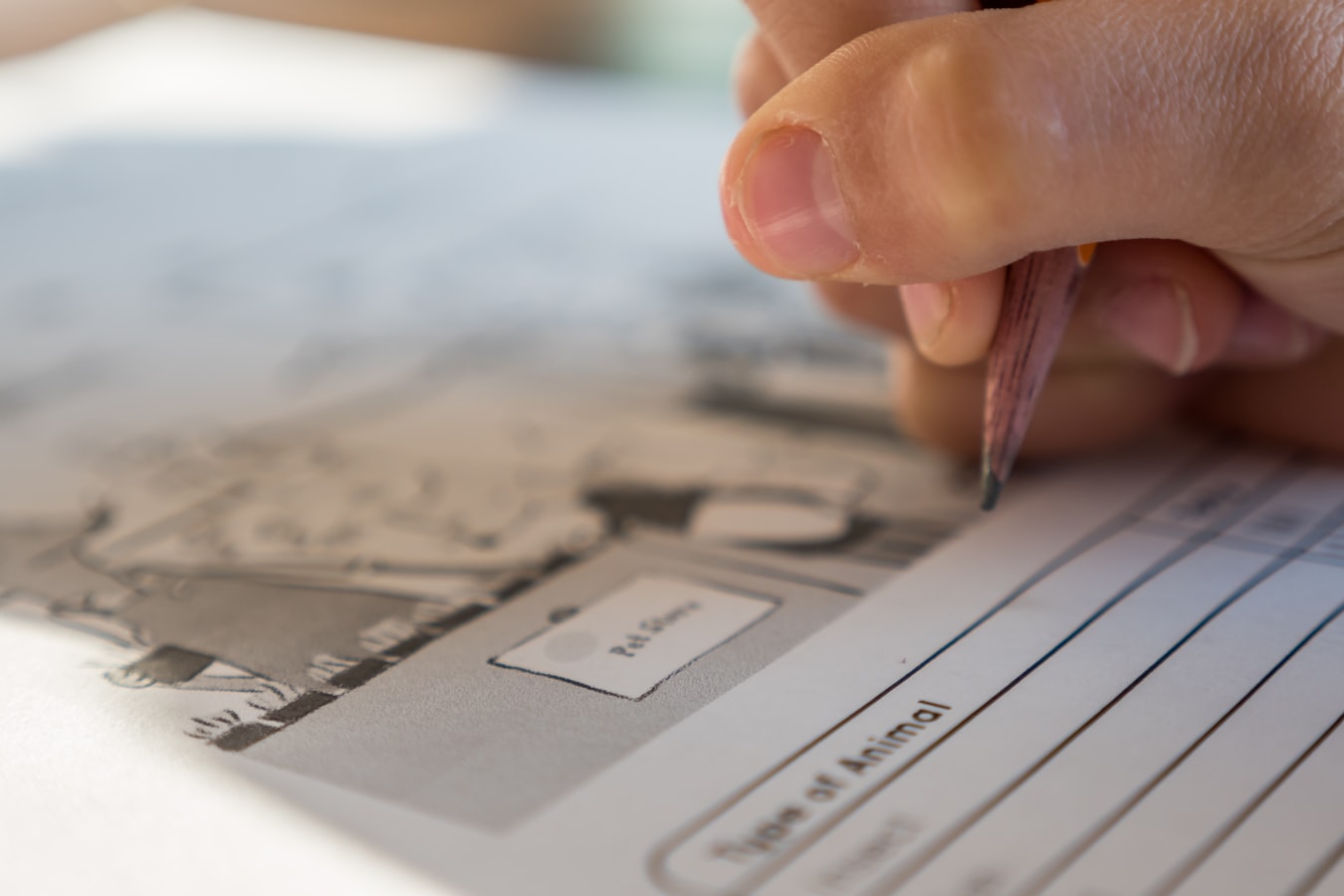 A person filling out a printed document form at a desk