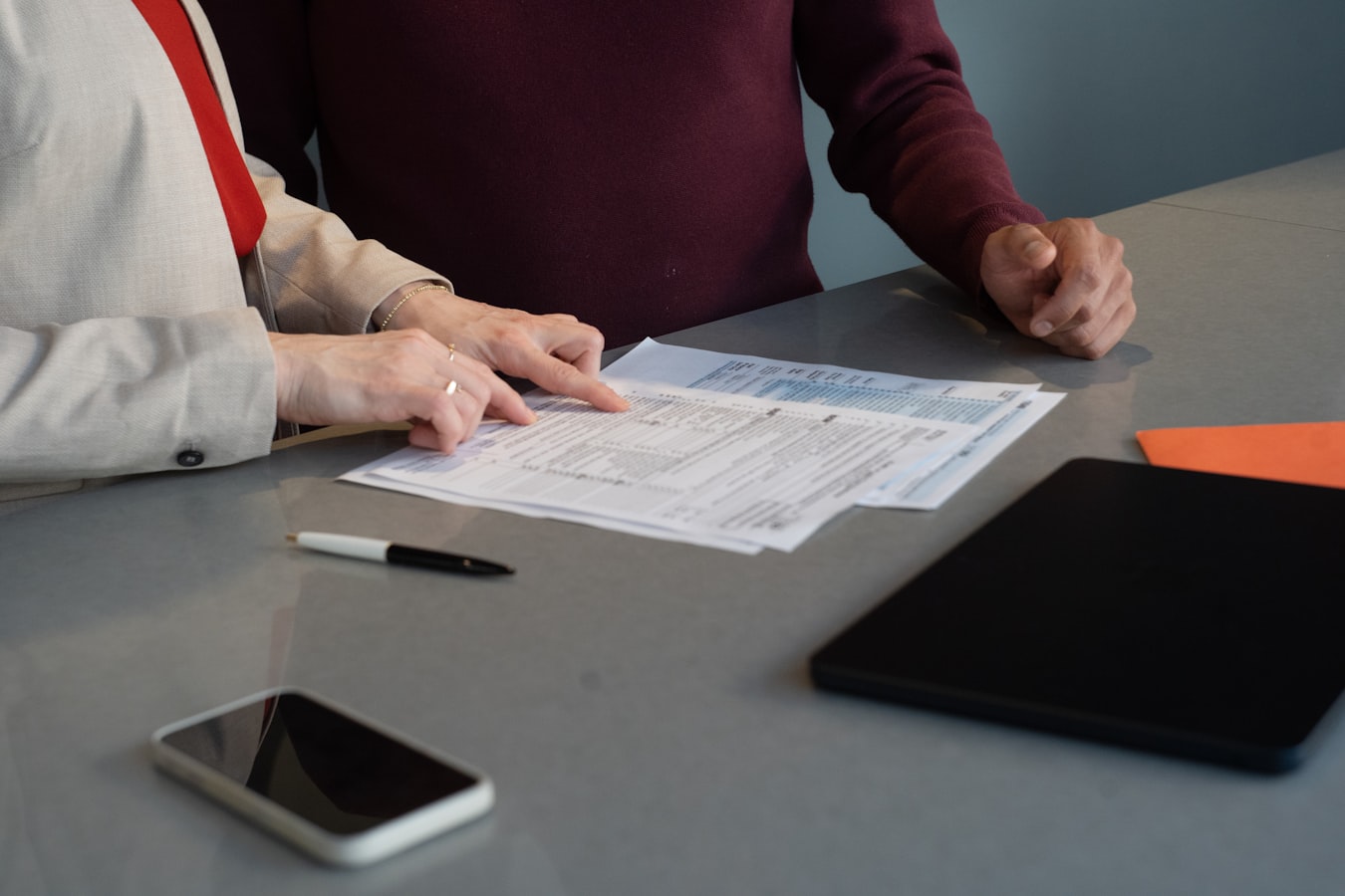 A short-term rental host reviewing printed house rules documentation at a desk