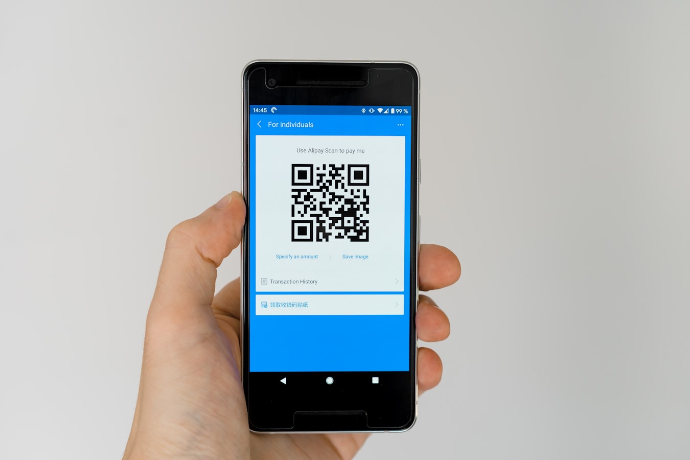 A person holding a smartphone up to scan a QR code on a card