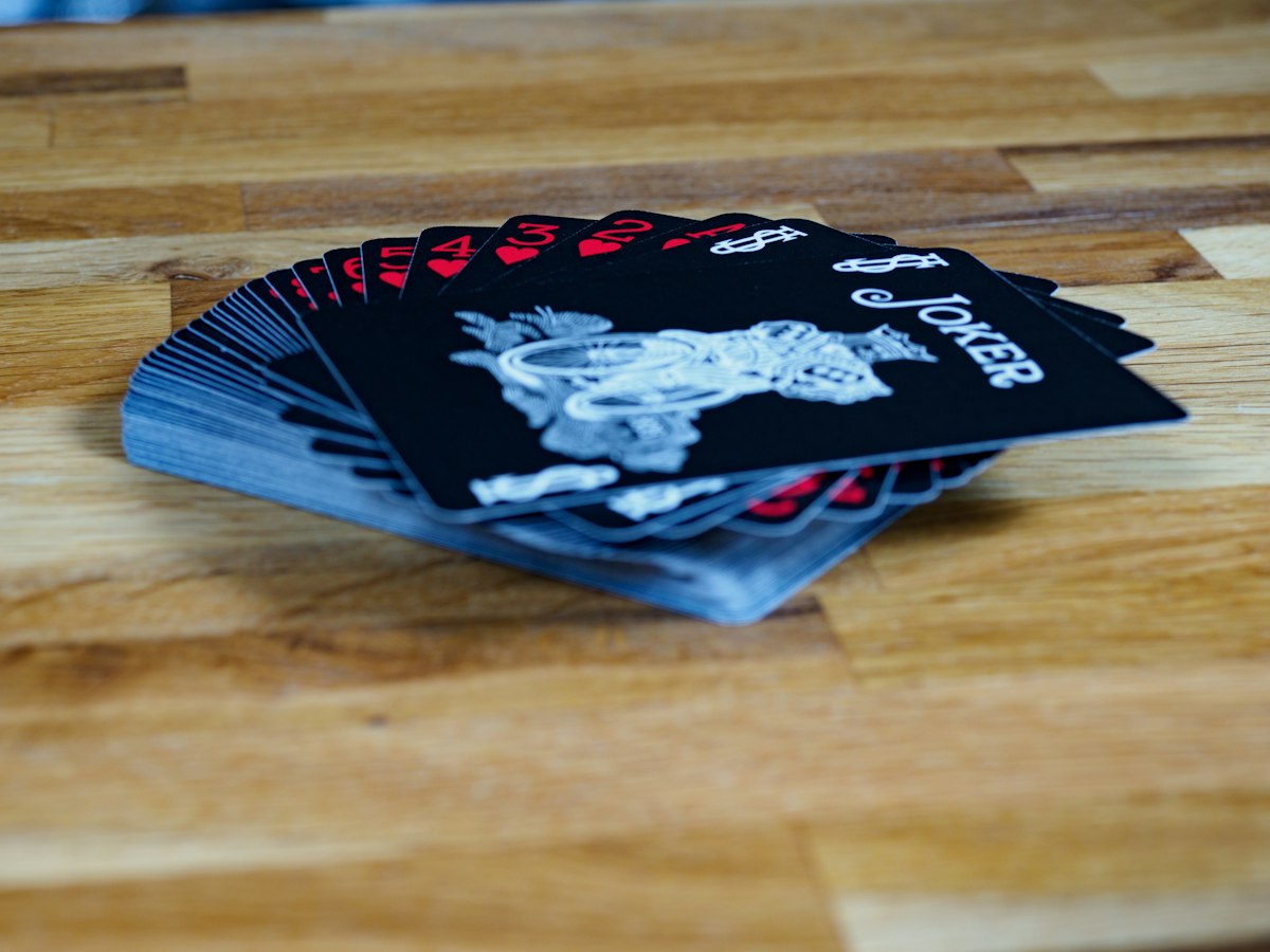 A small stack of personalized printed cards fanned out on a work table, showing slight variations in names and details across each piece.