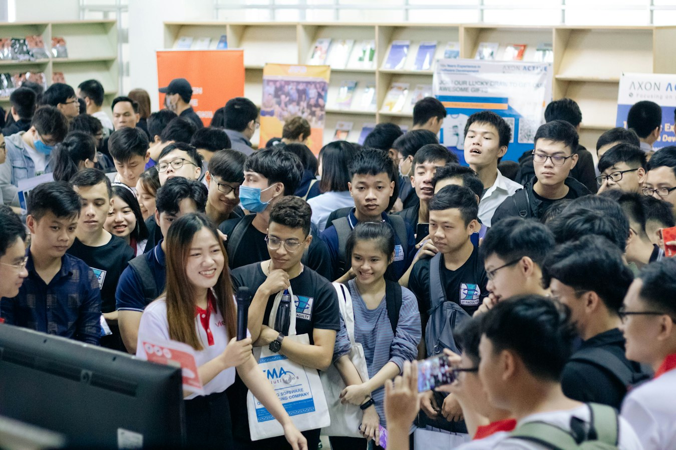 Two people shaking hands at a busy job fair