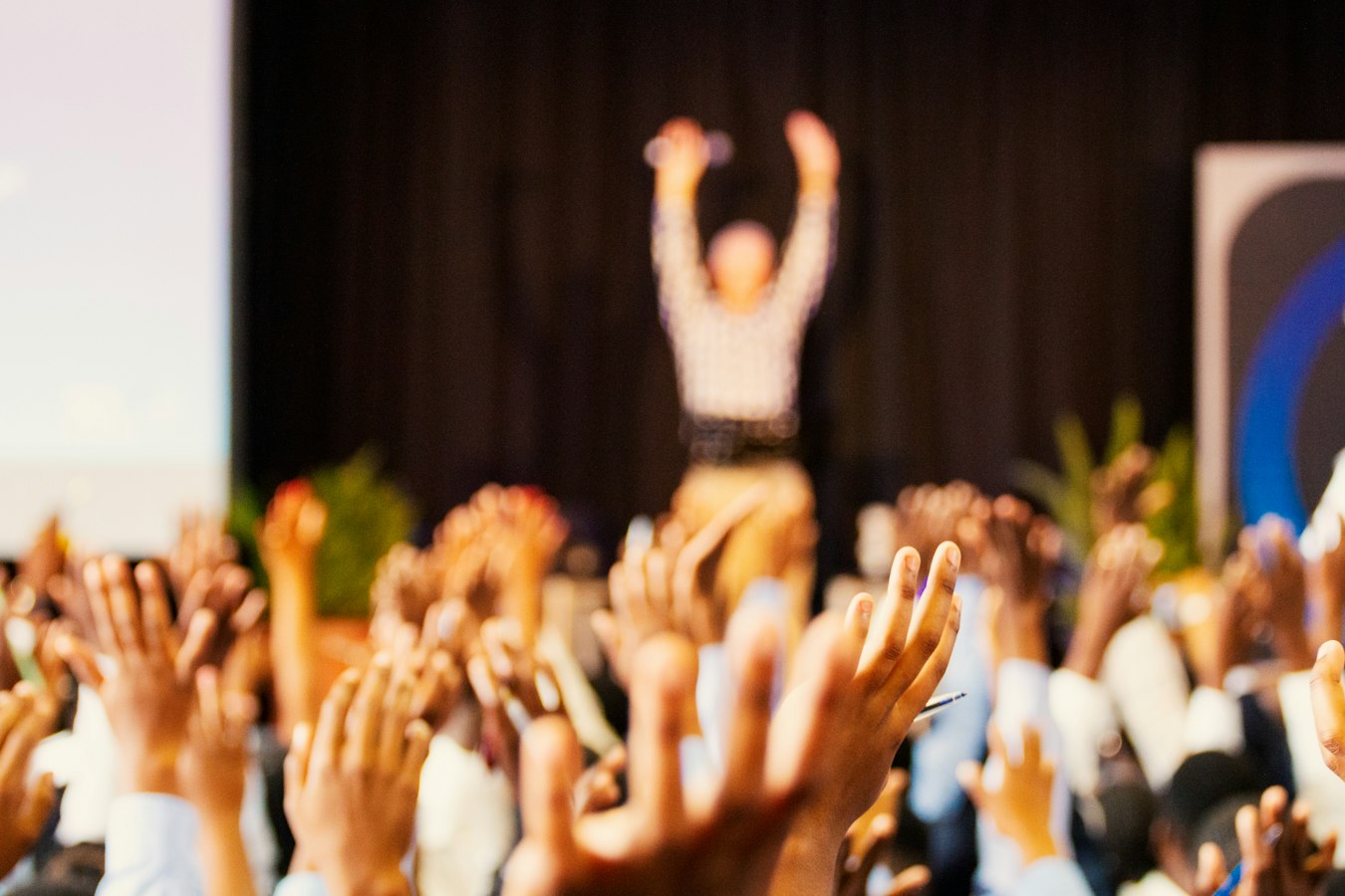 A speaker presenting on stage to an engaged audience