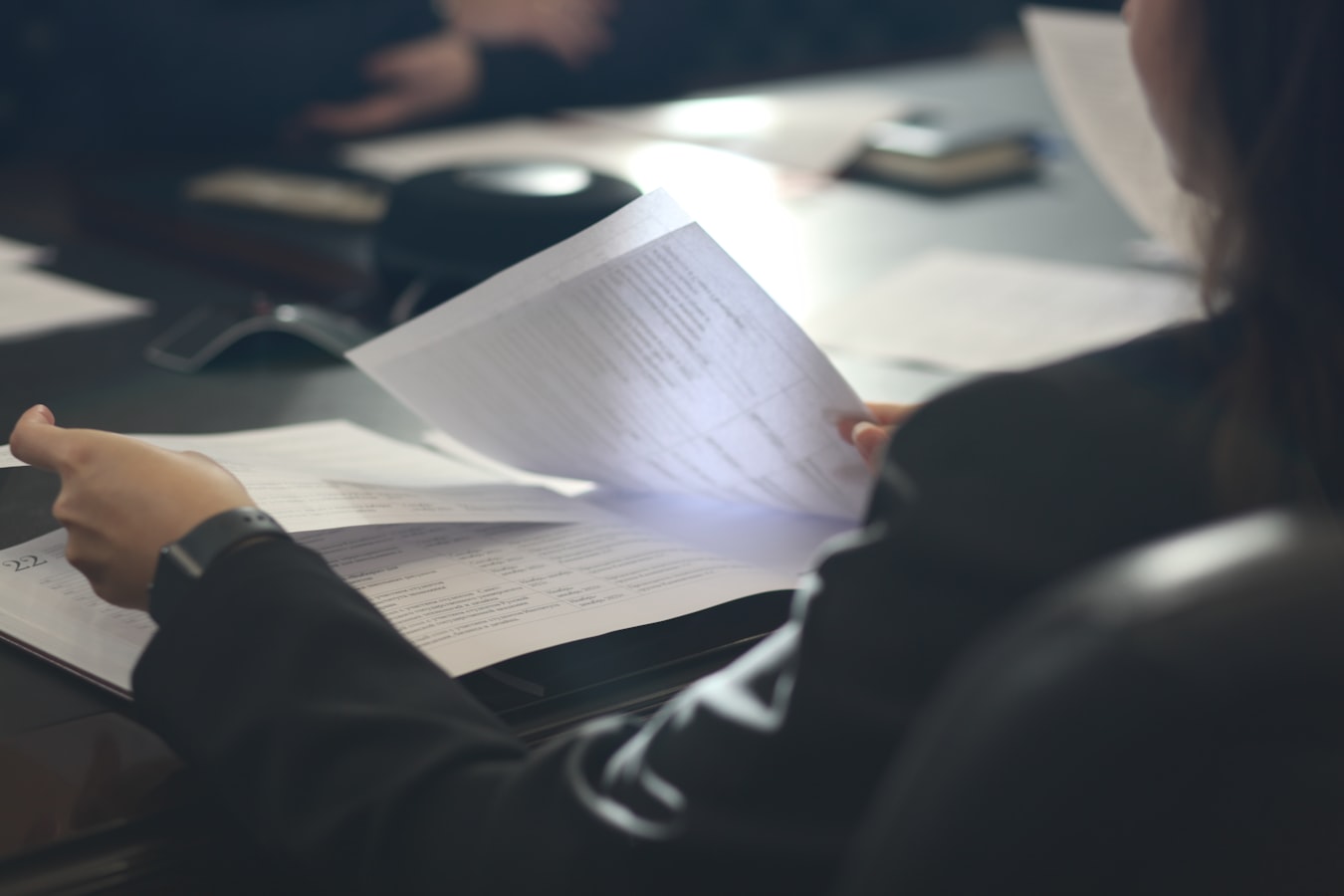 A host reviewing denial paperwork at a desk with a laptop open