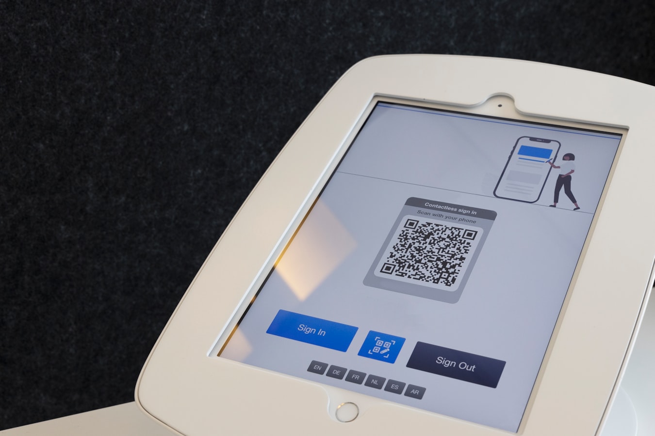 A person pointing their smartphone camera at a QR code to scan it