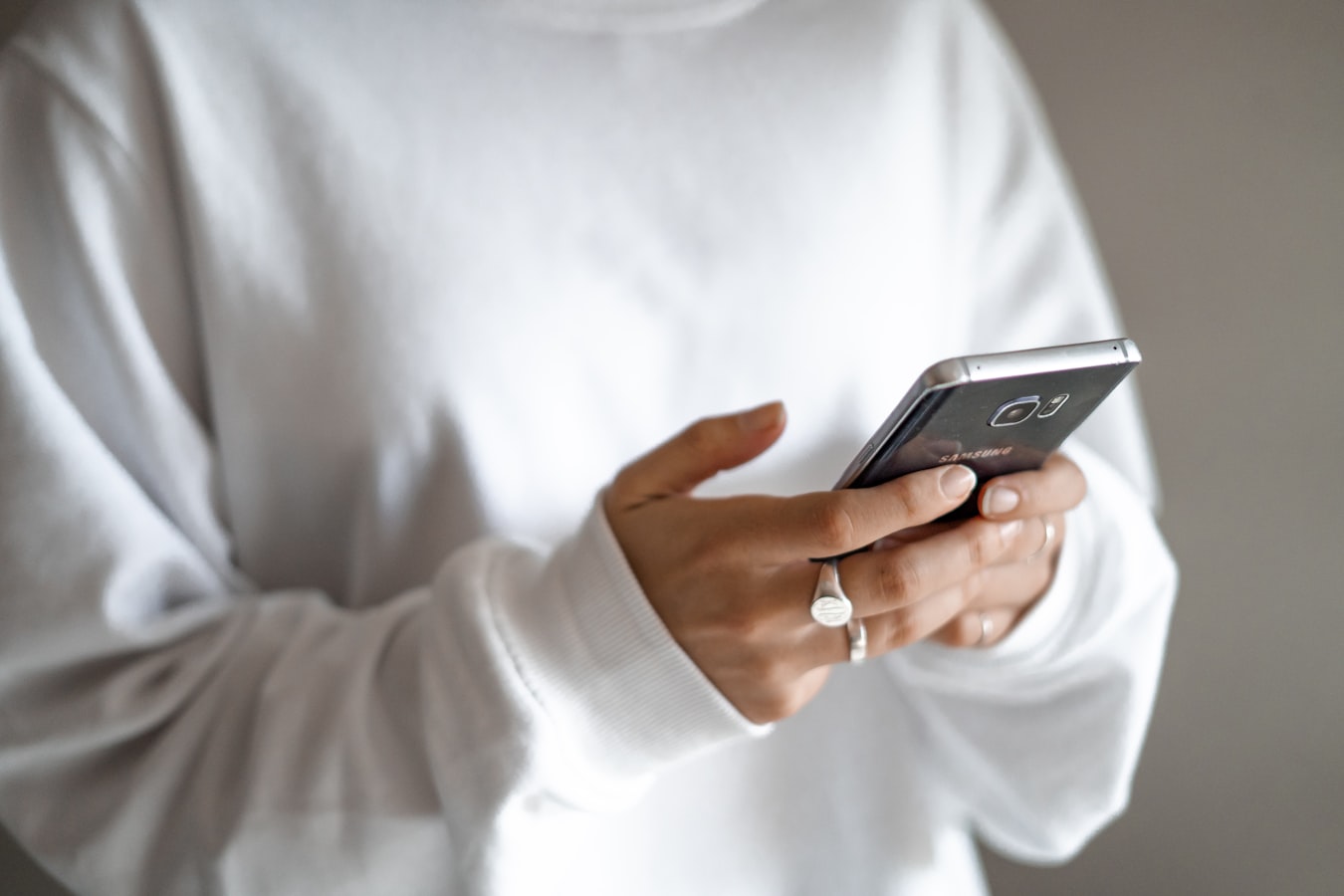A person holding a smartphone toward someone else to share contact information
