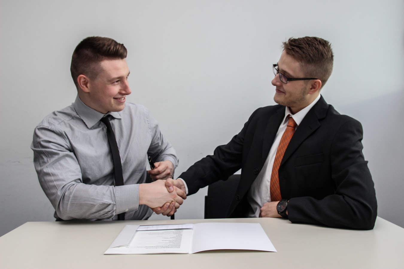 A coach and client shaking hands after a meeting