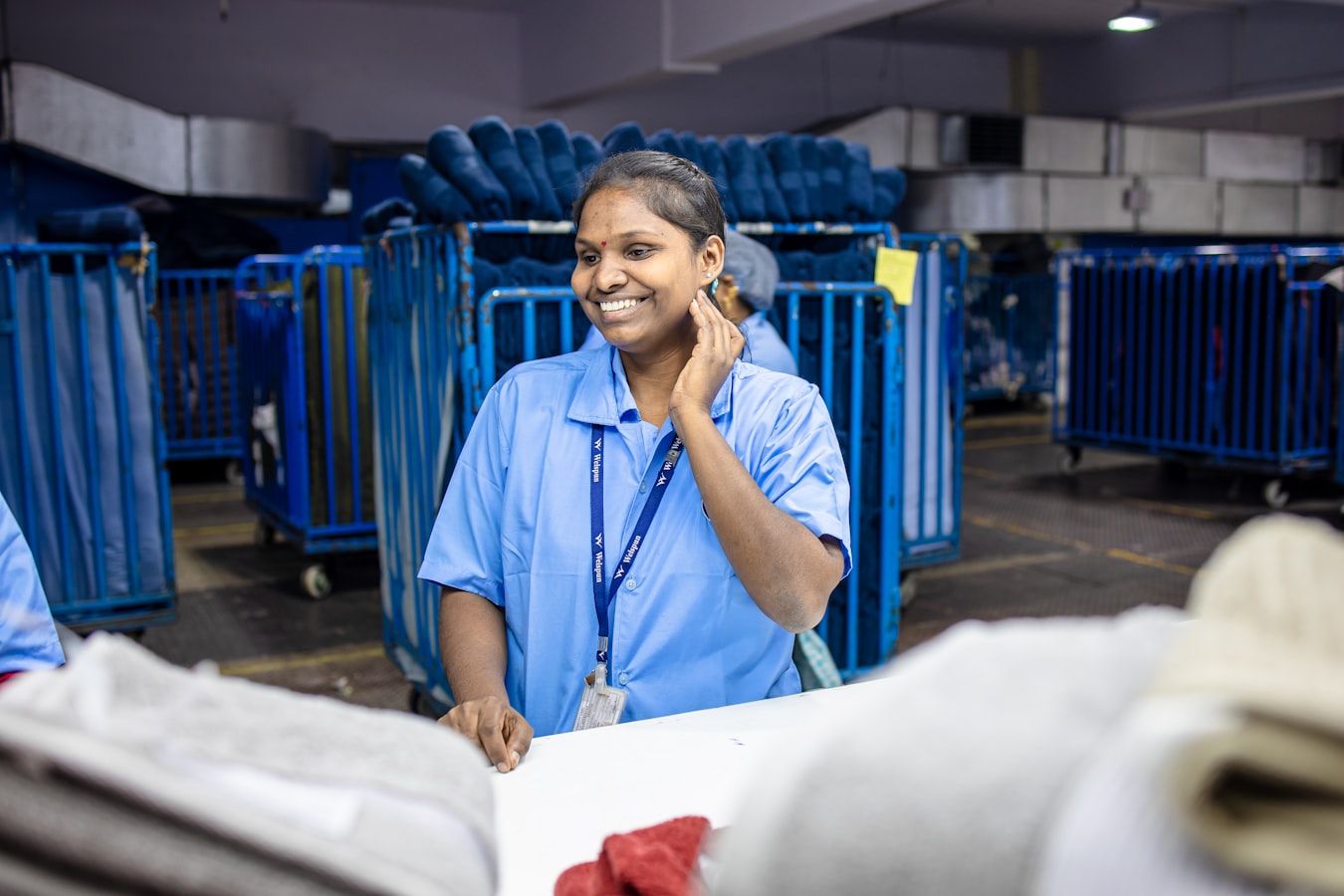 A healthcare professional smiling while holding a smartphone to share contact details