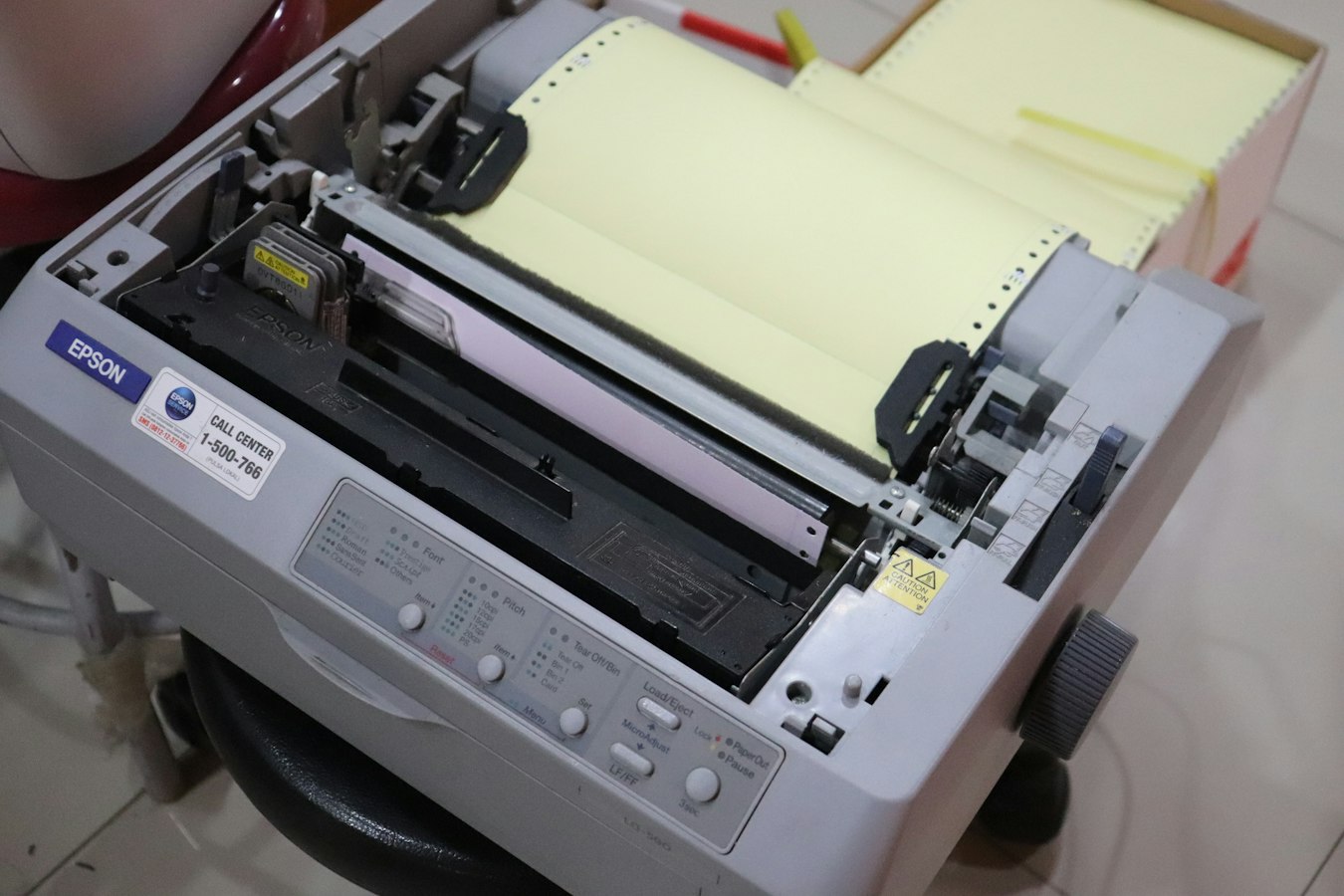 A sheet of blank white paper emerging from an office printer