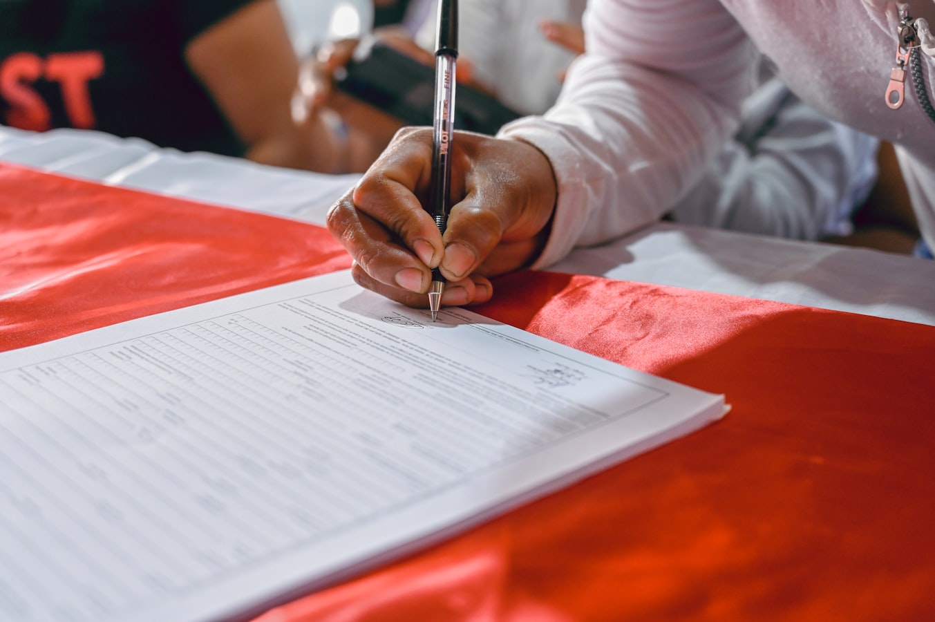 A parent reviewing and signing a photography release form with a photographer present