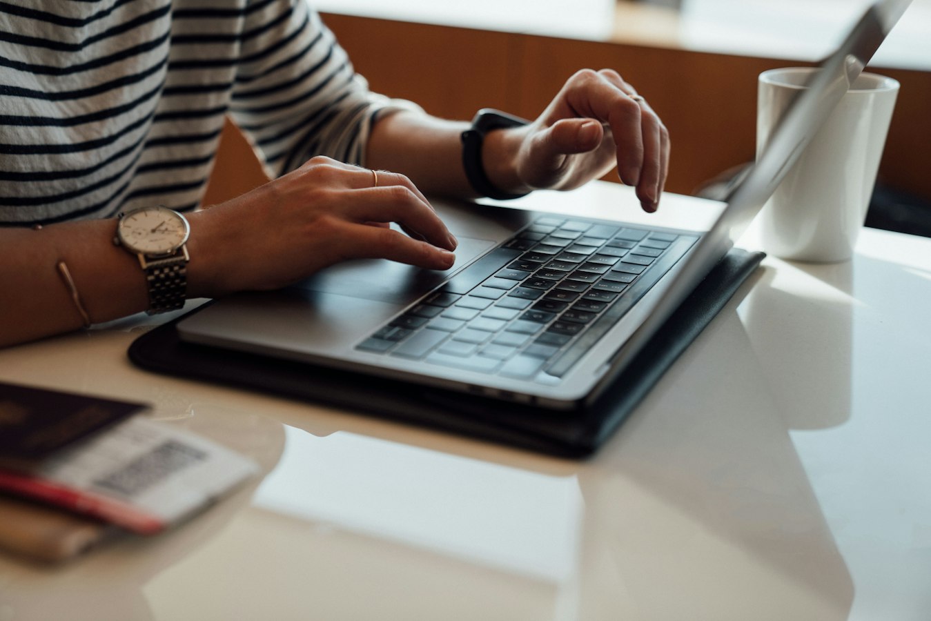 A person updating a document template on a laptop at a desk