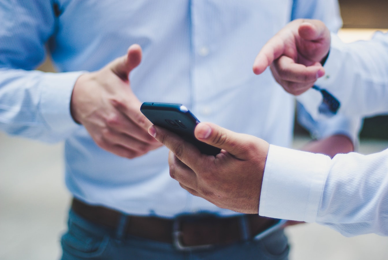 Two people tapping phones together to share contact information