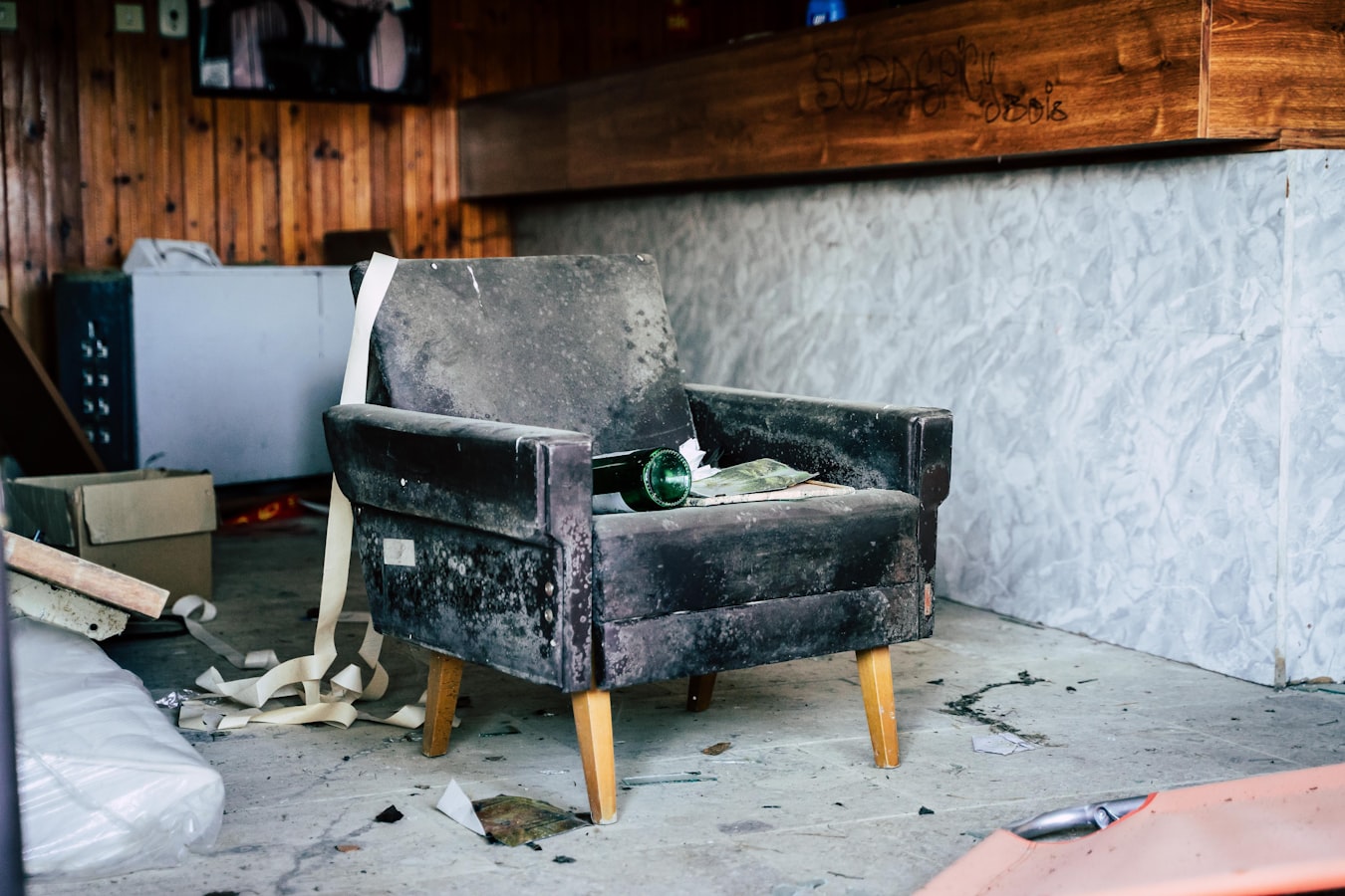A cracked wooden chair in a bright, furnished short-term rental living room