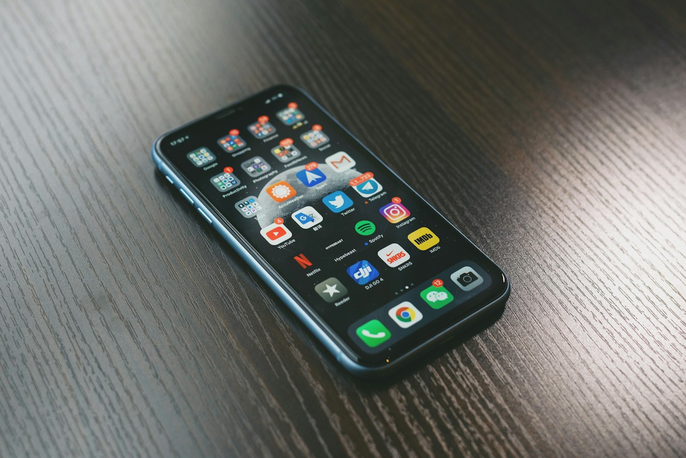 A smartphone on a desk surrounded by connected app icons representing digital integrations