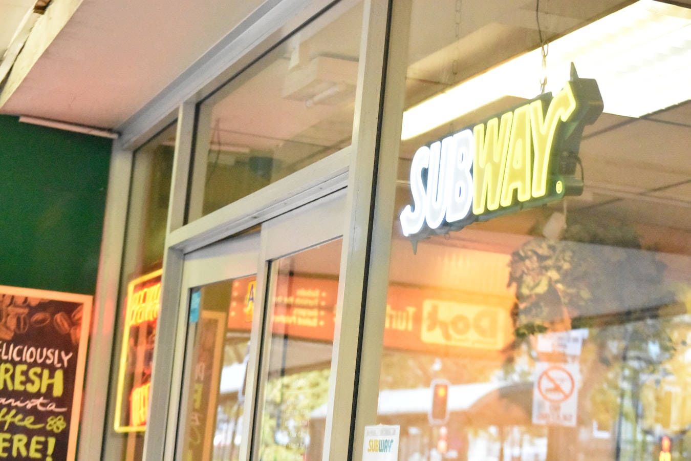 Rows of matching franchise storefronts viewed from above, showing consistent branding across multiple locations