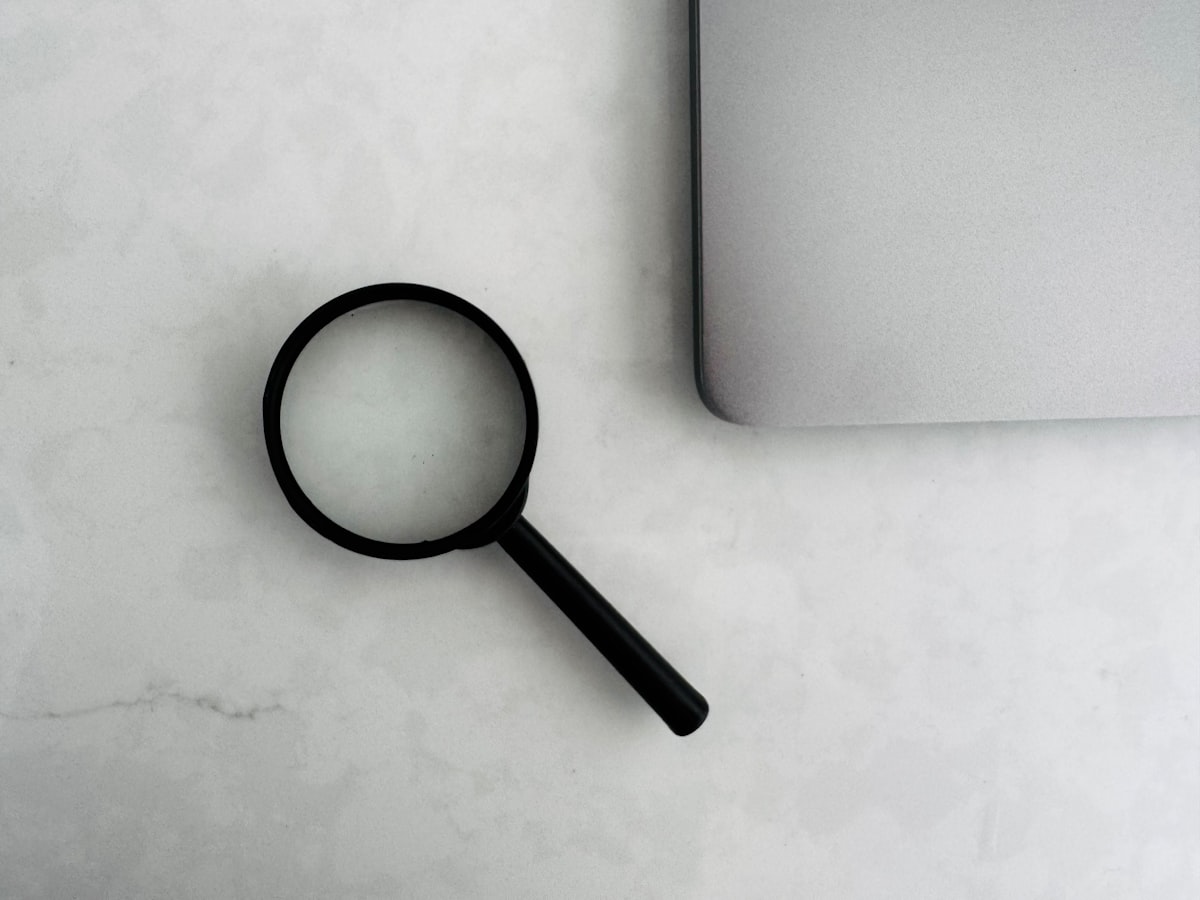 A magnifying glass resting on a printed data report, representing measurement and analysis
