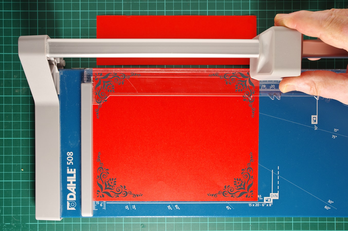 A guillotine cutter trimming the edge of a printed sheet to the final trim size