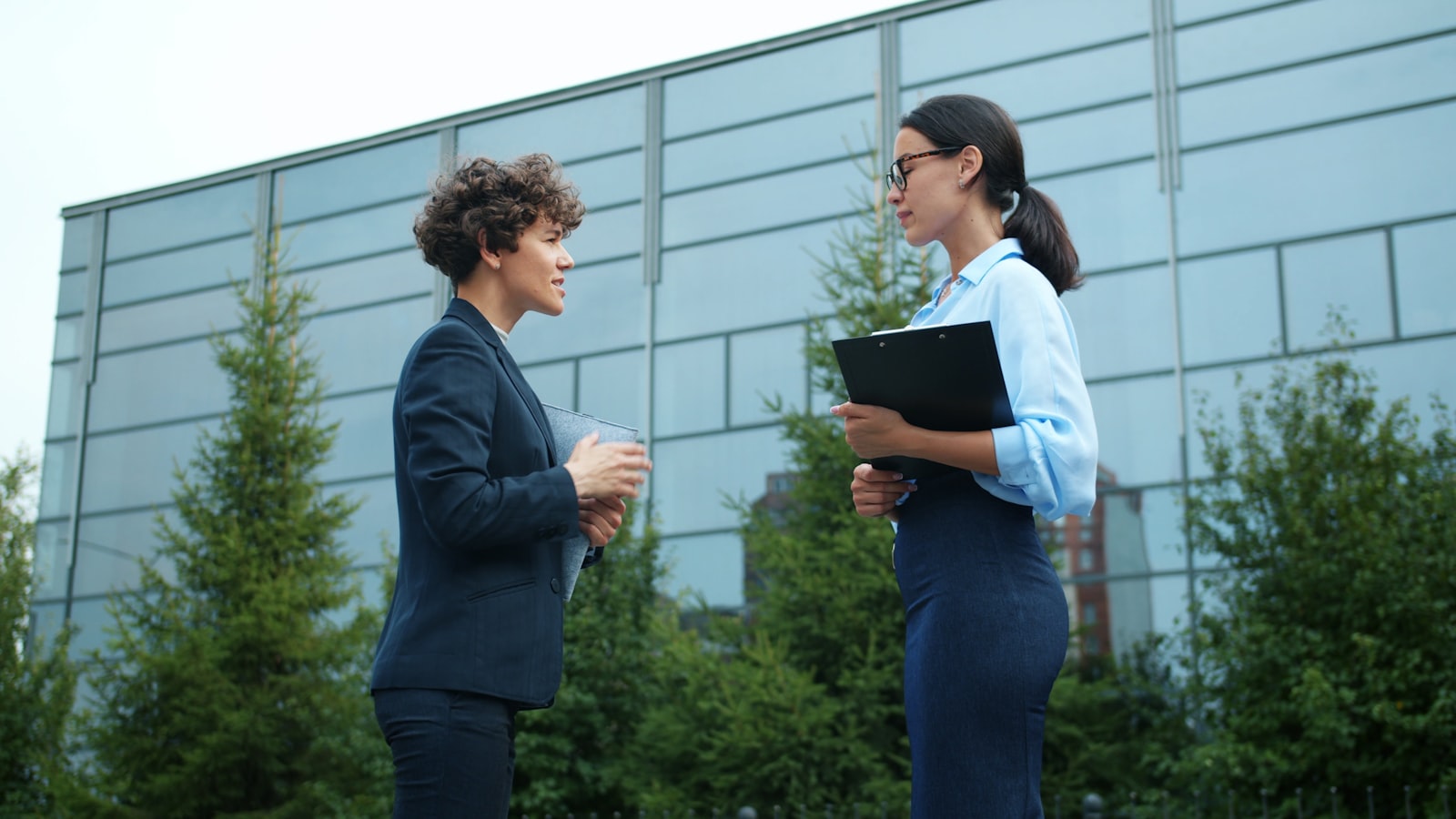 A real estate agent shaking hands with a client outside a home
