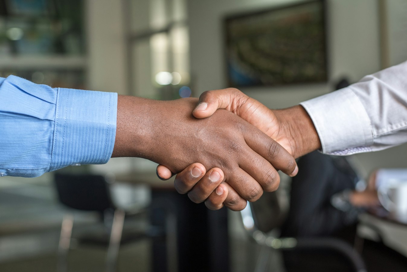 An HR professional warmly greeting a job candidate across a desk