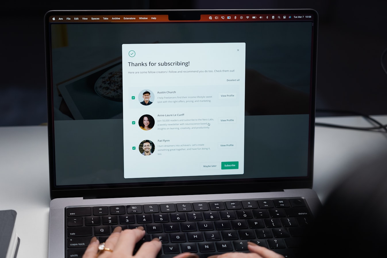 A professional reviewing synced contact details on a laptop at a clean desk