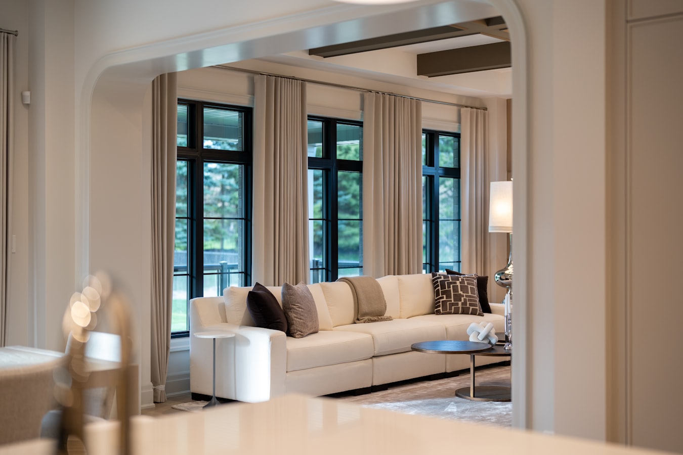 Photographer setting up a camera on a tripod inside a bright, staged living room for a real estate shoot
