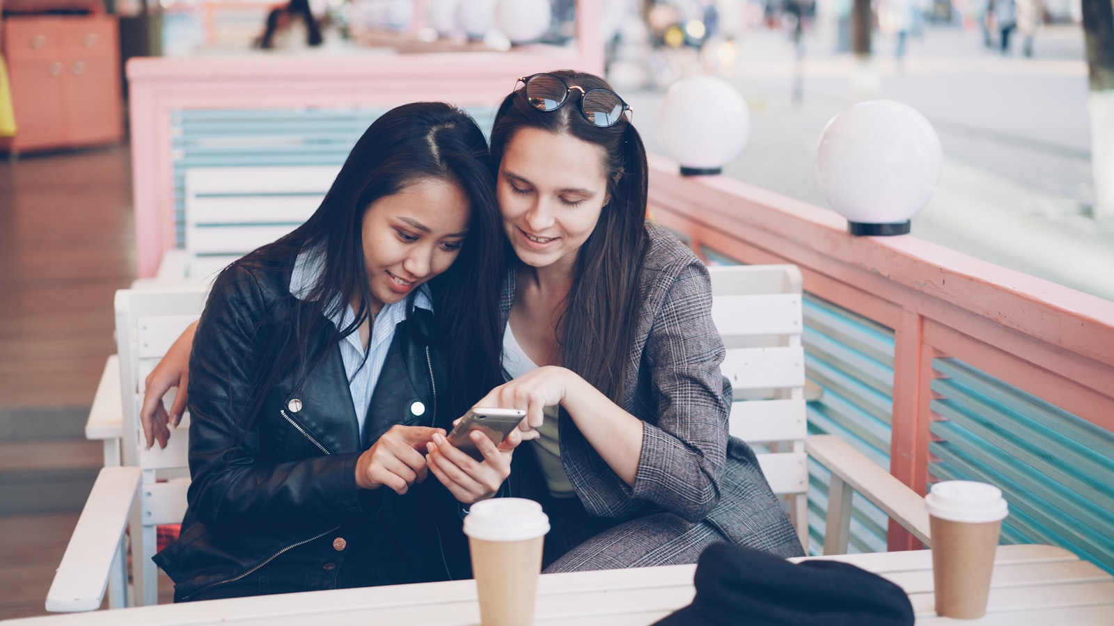 A professional glancing at their phone while connecting with someone in a relaxed outdoor setting