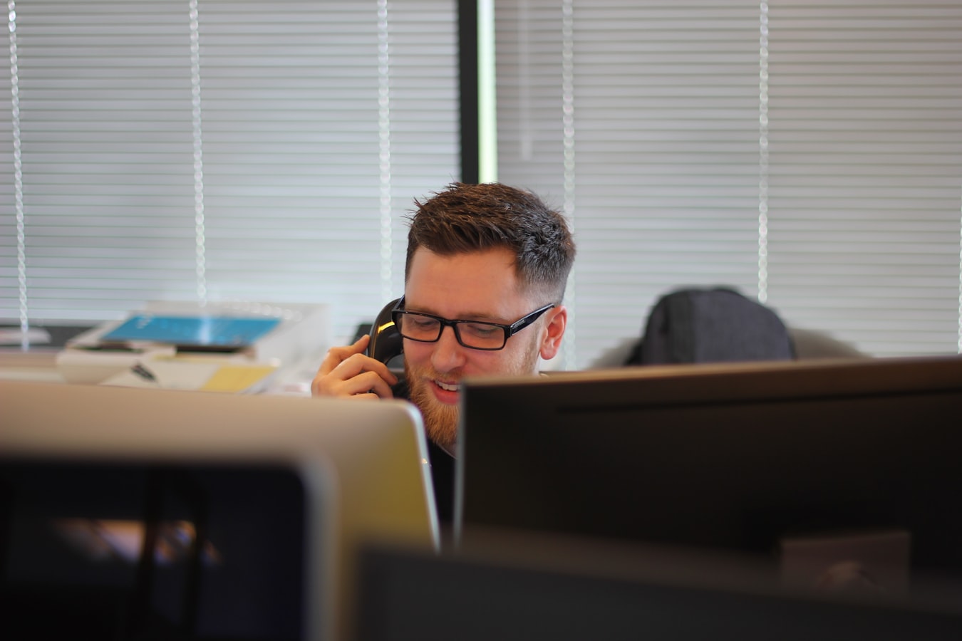 A freelancer sharing their contact details from a phone with a client at a café table
