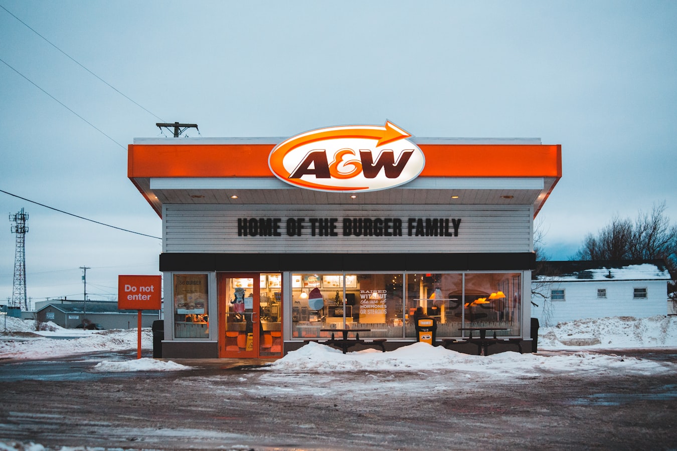 A row of matching franchise storefronts with consistent exterior branding and signage