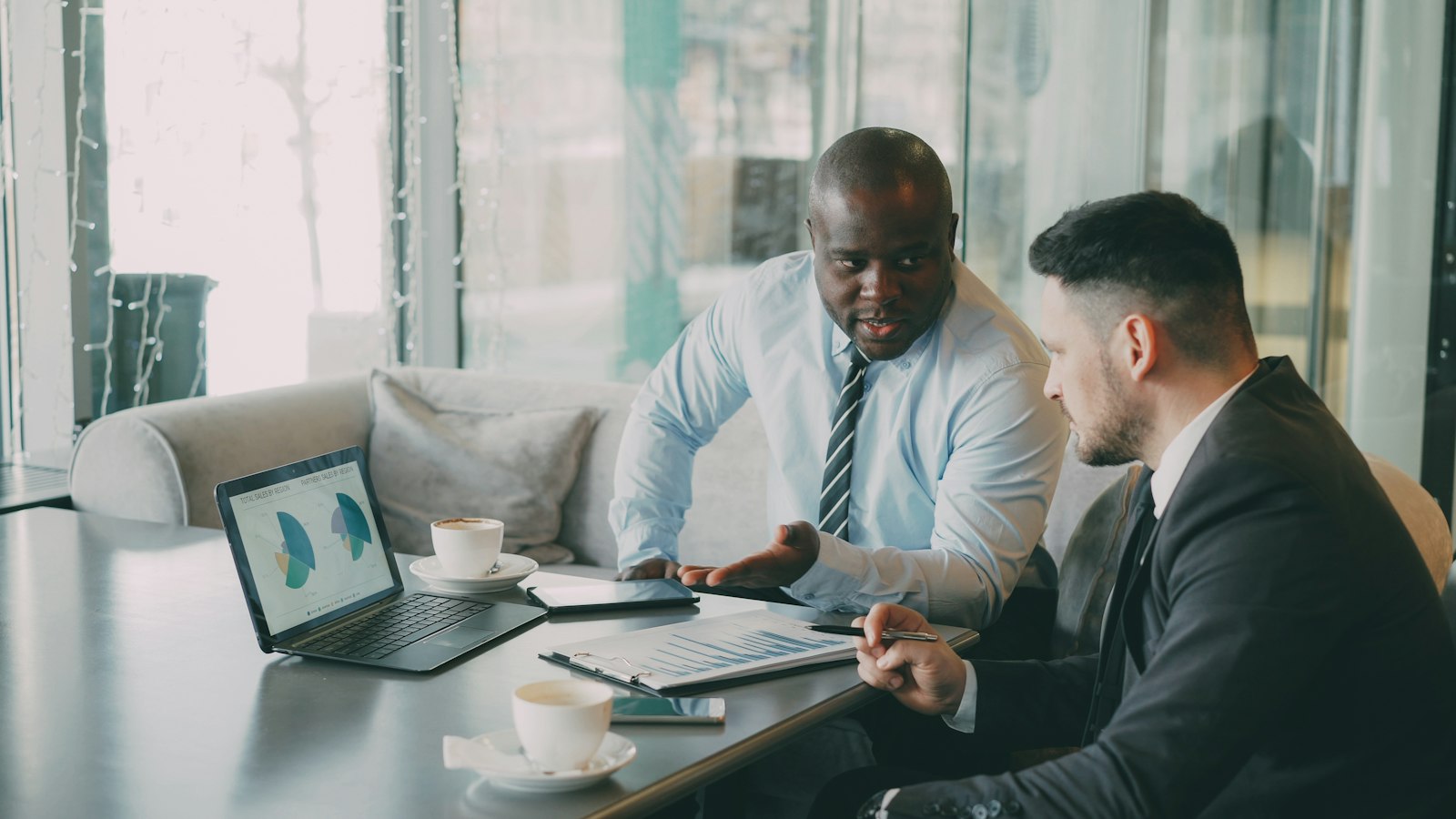 A finance professional sharing contact details on a smartphone during a client meeting
