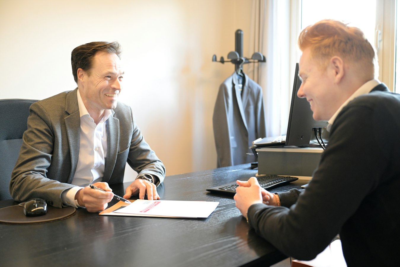 An accountant sitting across a desk from a client in a professional office setting