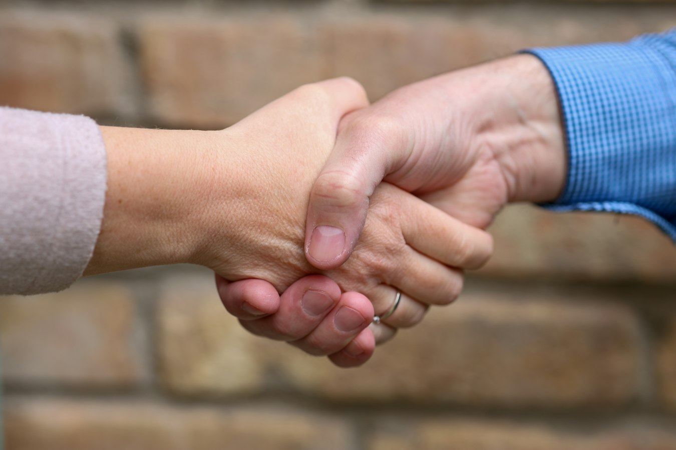 A contractor shaking hands with a client at a job site