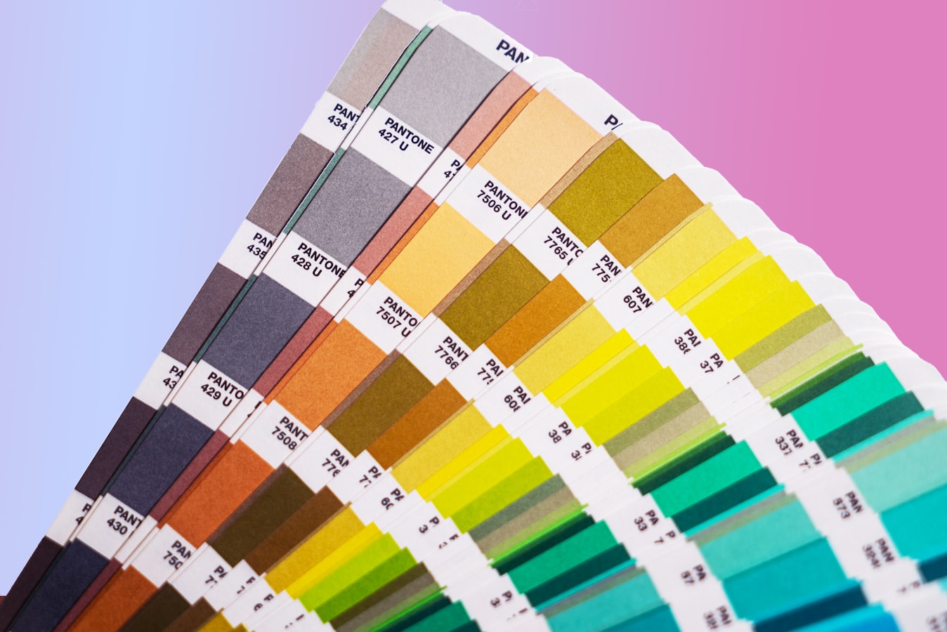 A fan of Pantone spot color swatches laid on a commercial printing press sheet