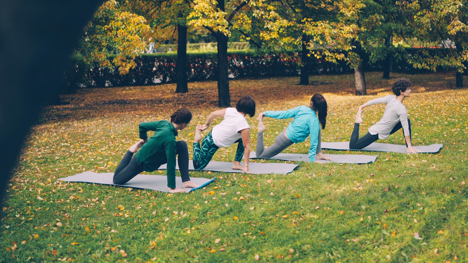 Photographer documenting a group yoga session at an outdoor fitness retreat