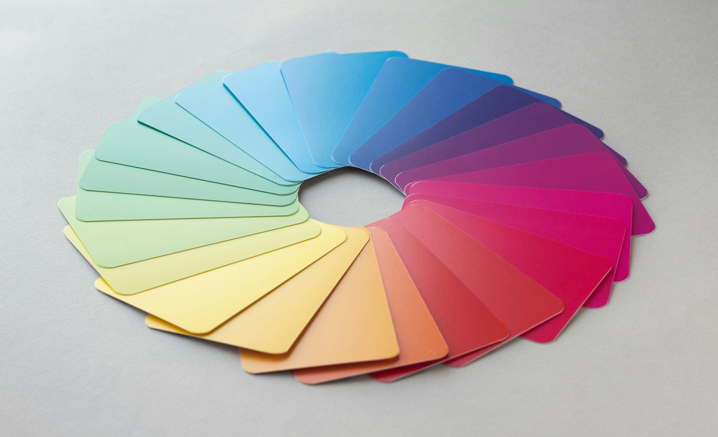 Pantone swatch fan deck next to CMYK printed color samples on a press sheet