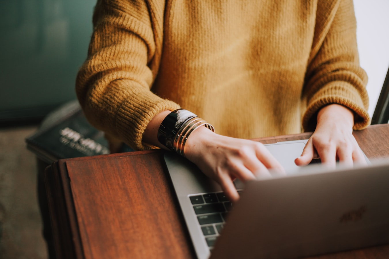 A person composing an email on a laptop at a clean desk