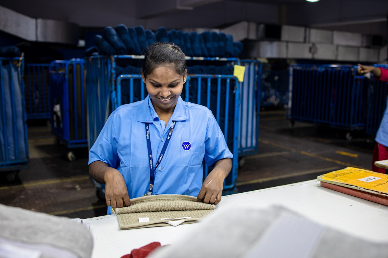 A print shop worker reviewing a stack of printed documents at a production workstation