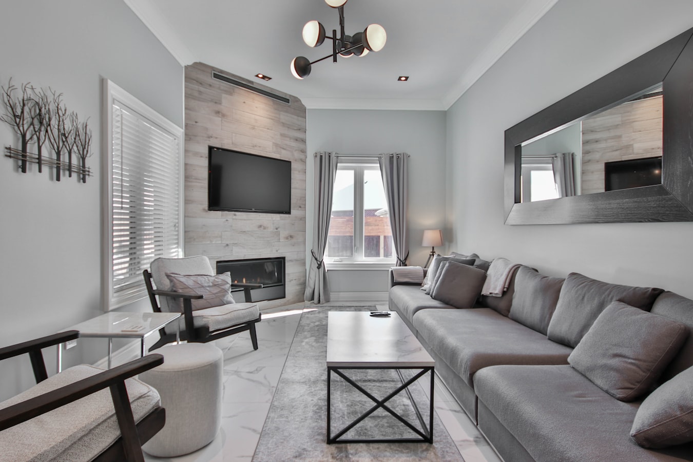 Overturned furniture and scattered cups left in a vacation rental living room after guest damage