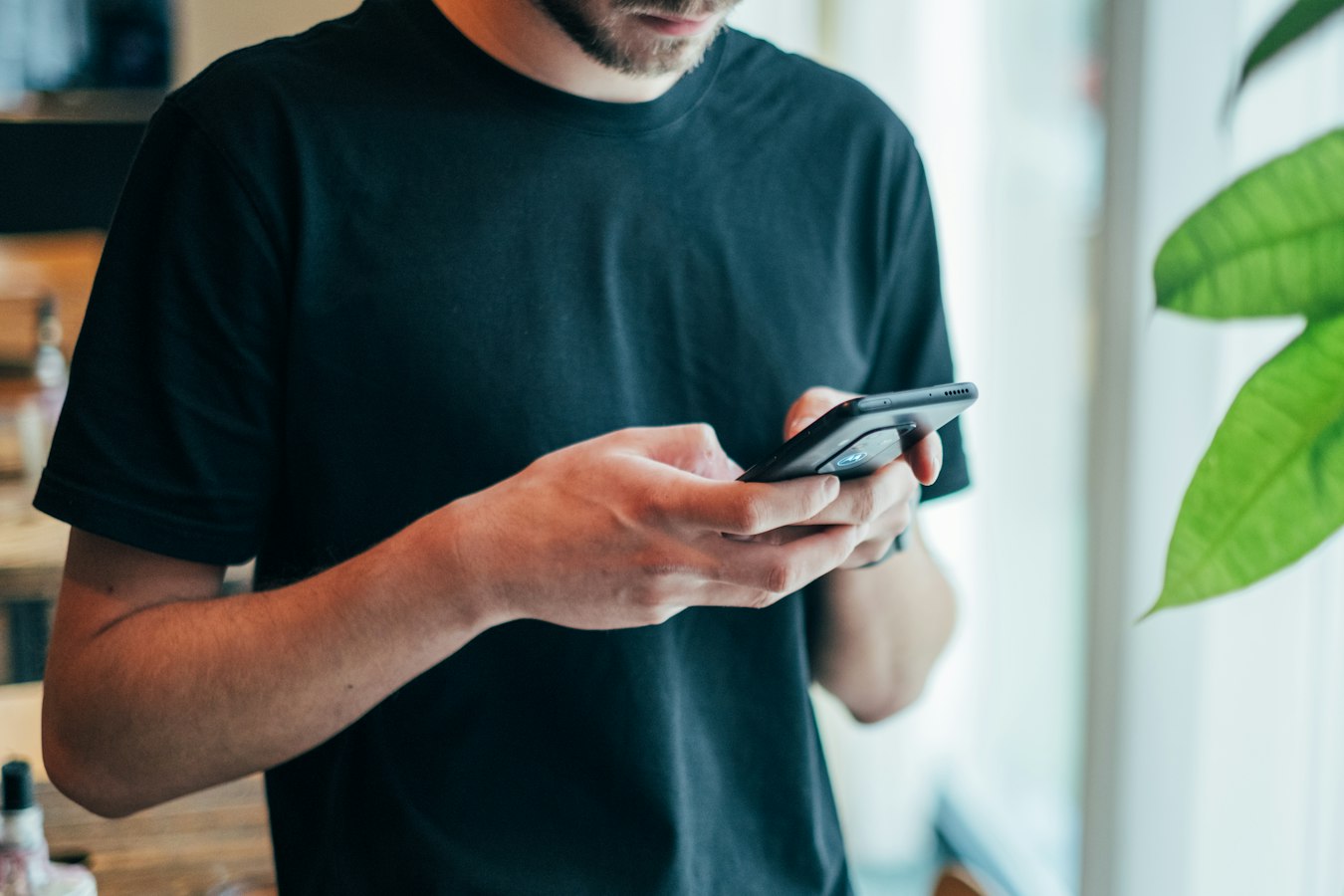 Person typing a text message on a smartphone to share contact information