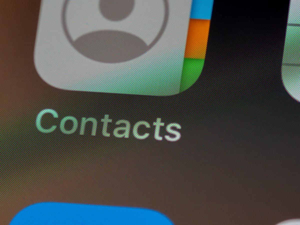 A person tapping their phone to share contact details with someone else