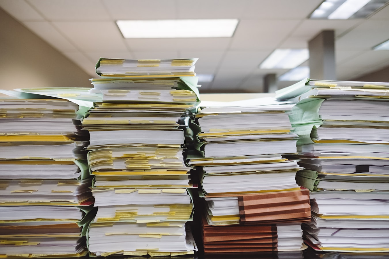 Stacked printed sheets organized on a print shop work table representing template version control