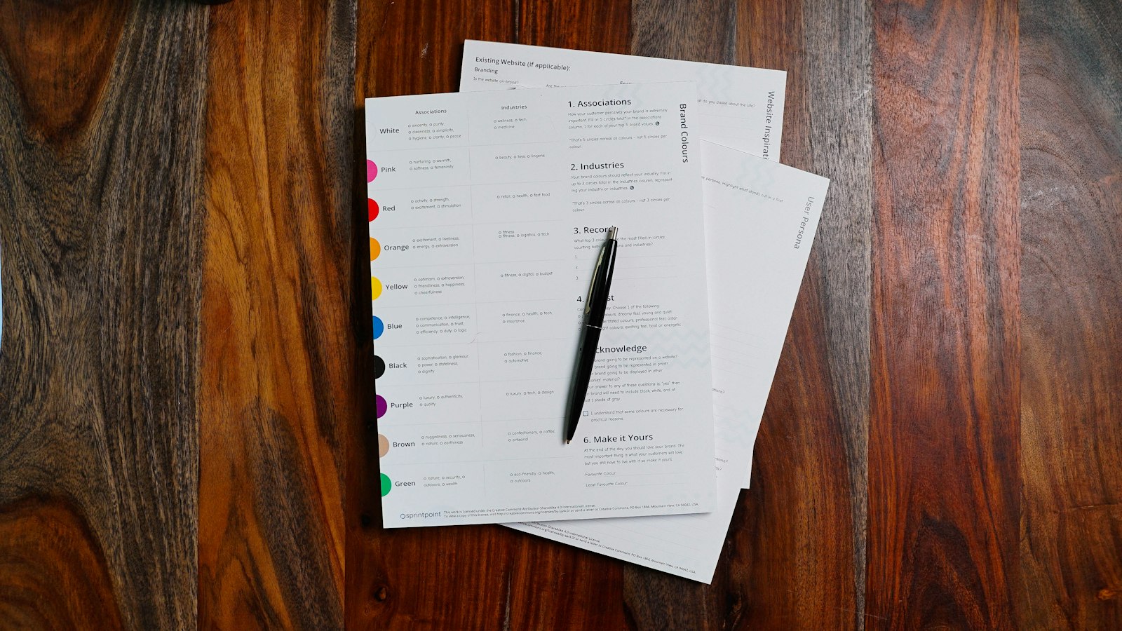 A tidy real estate office desk with printed documents and a pen