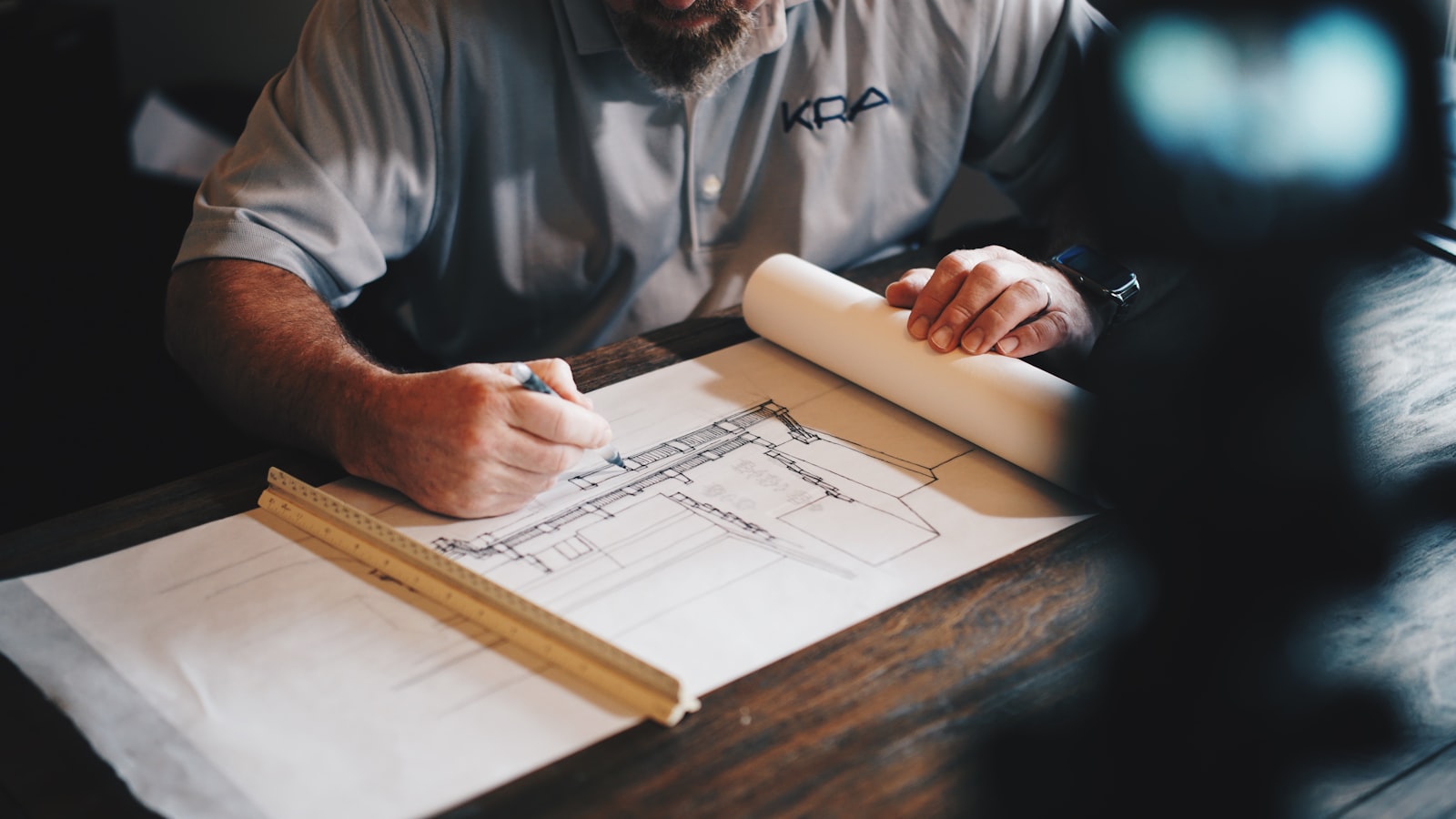 An architect reviews blueprints at a drafting table
