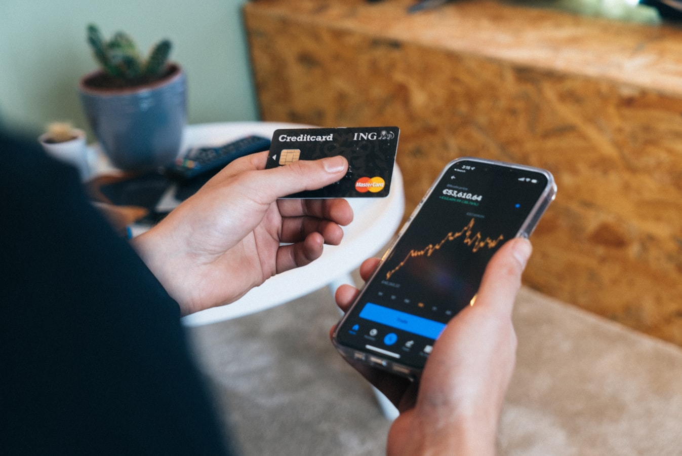A hand holding a paper business card next to a smartphone displaying a digital contact page