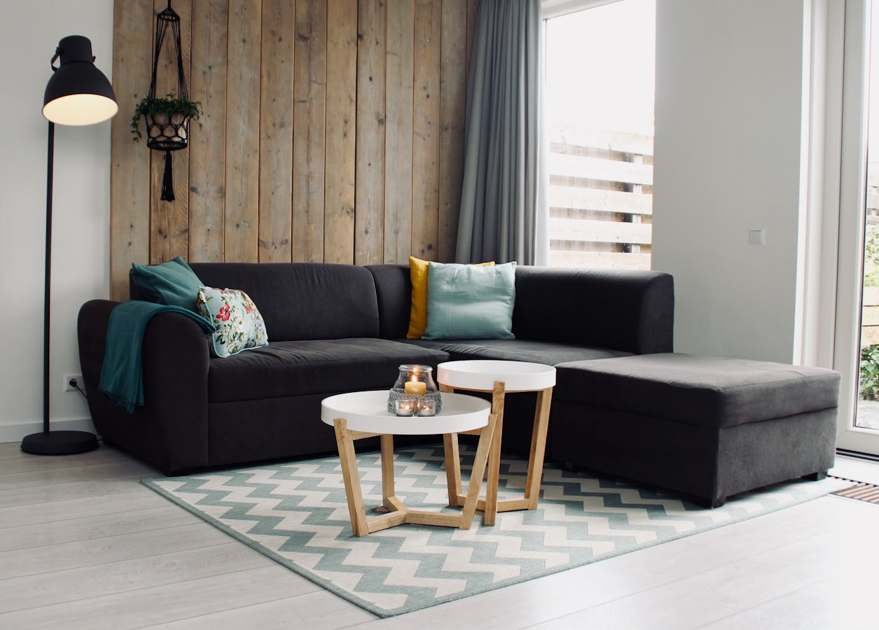 A tidy short-term rental living room with a printed house rules sheet on the coffee table