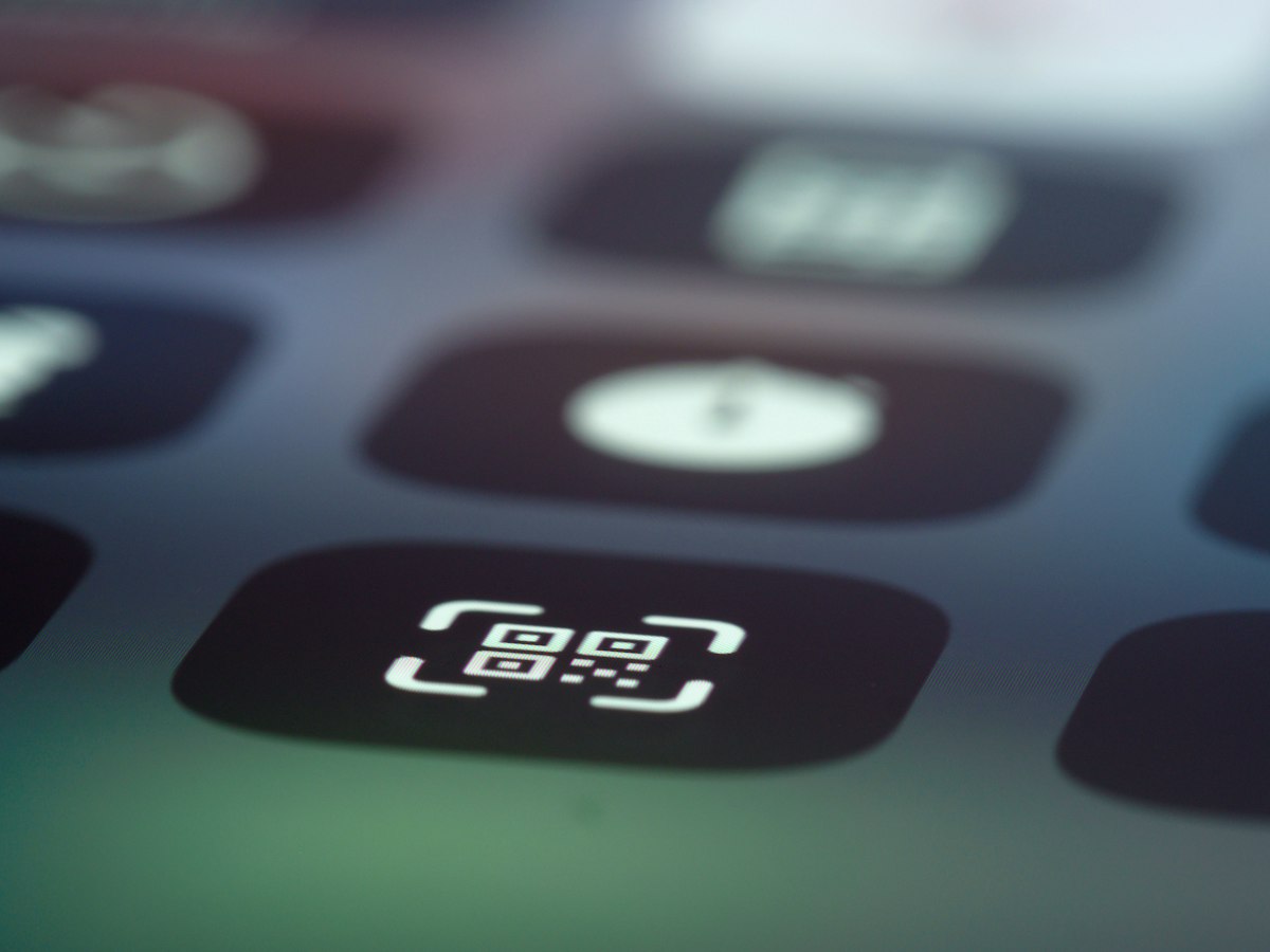 A person scanning a QR code on a business card with their smartphone