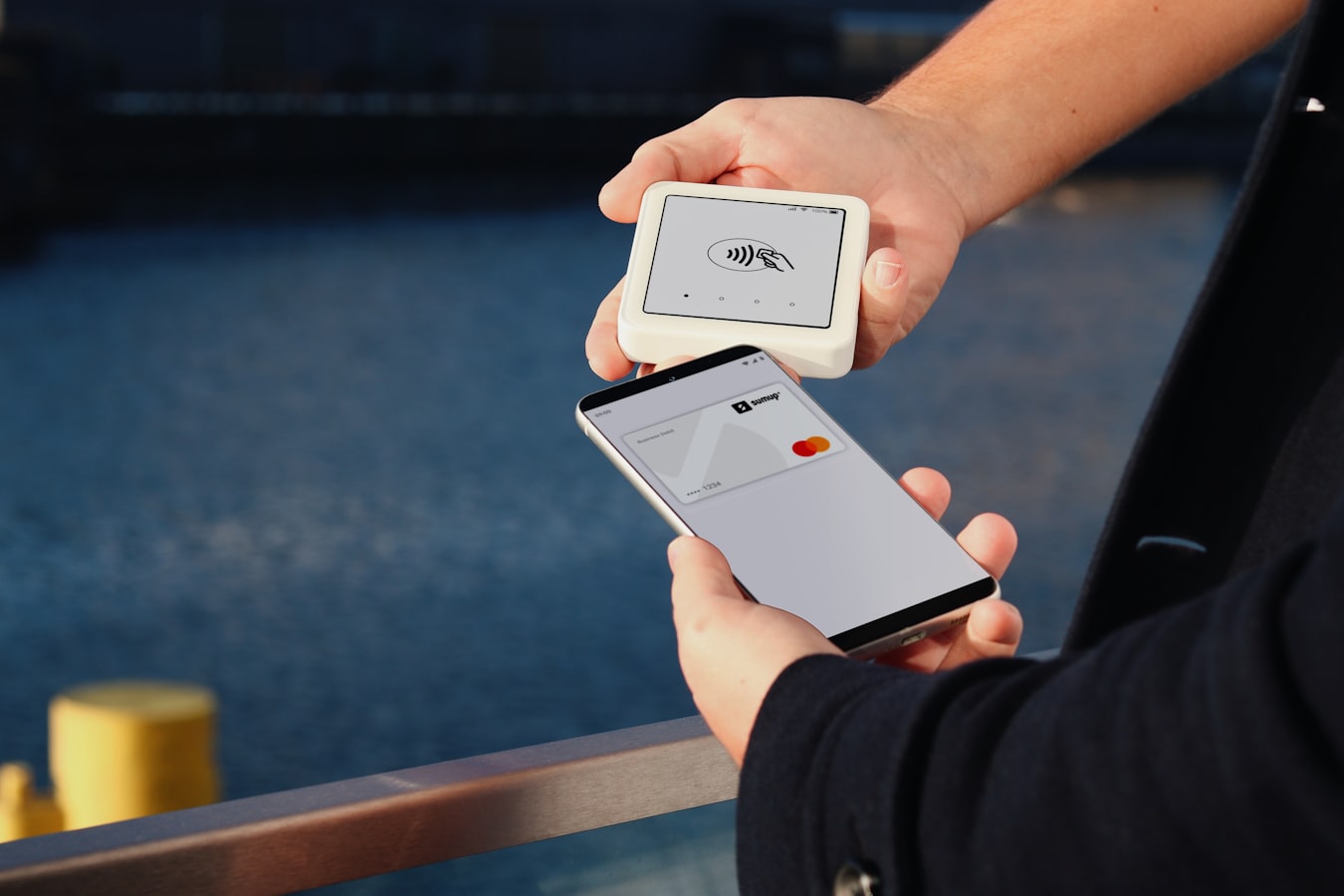 A person tapping an NFC business card to a smartphone to share contact details