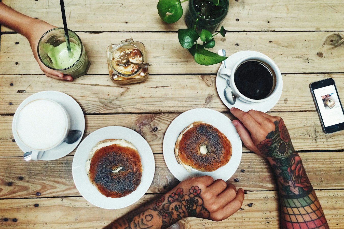 Two people sharing contact information on their phones over coffee