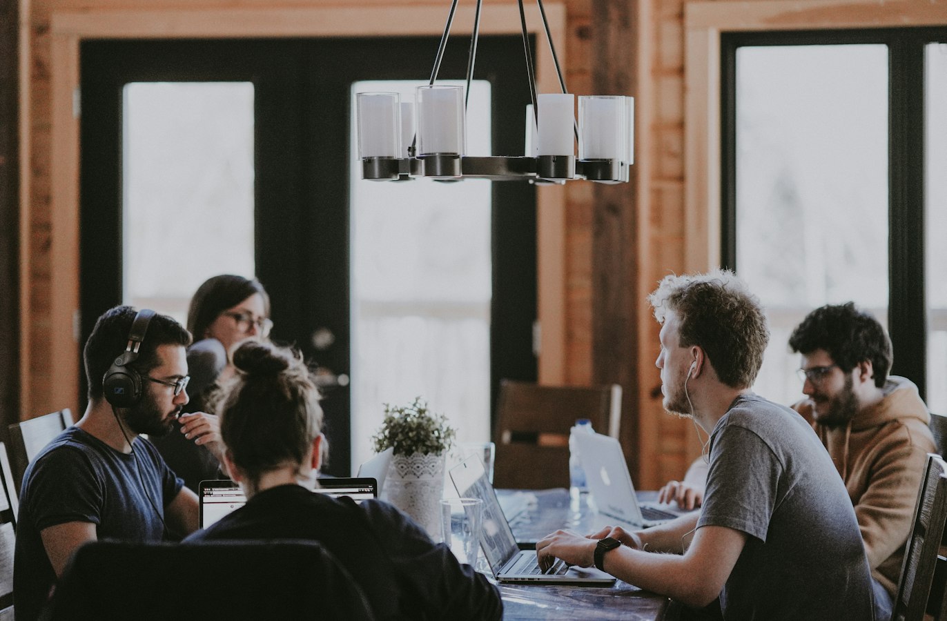 A small startup team gathered around a table, talking and collaborating